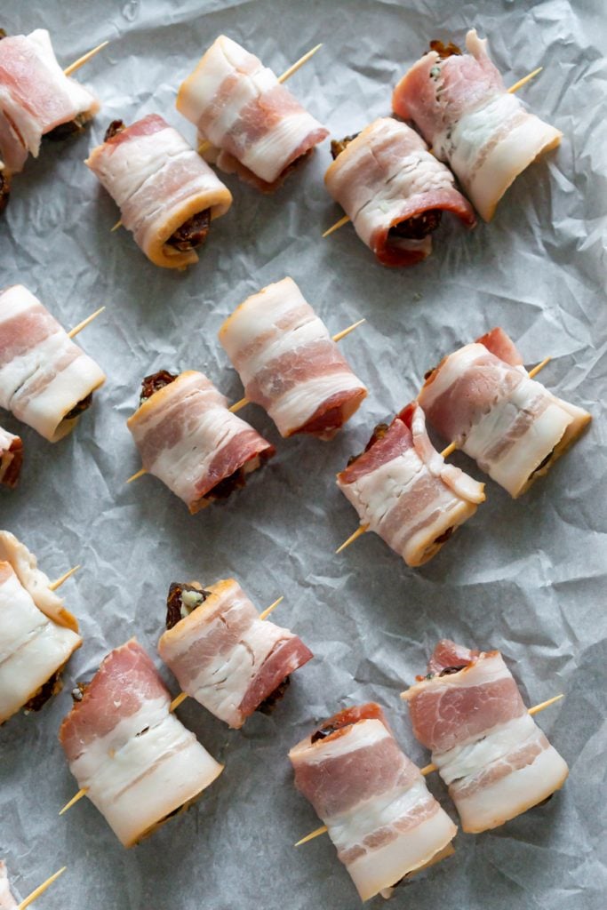 dates wrapped in bacon on parchment paper