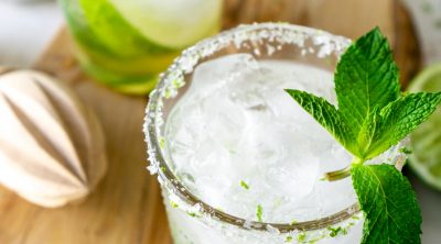 two mint mojitos on a wood serving tray