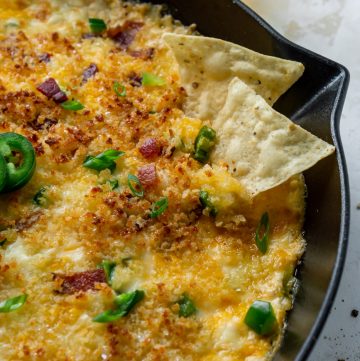 chips dipping into jalapeno popper dip