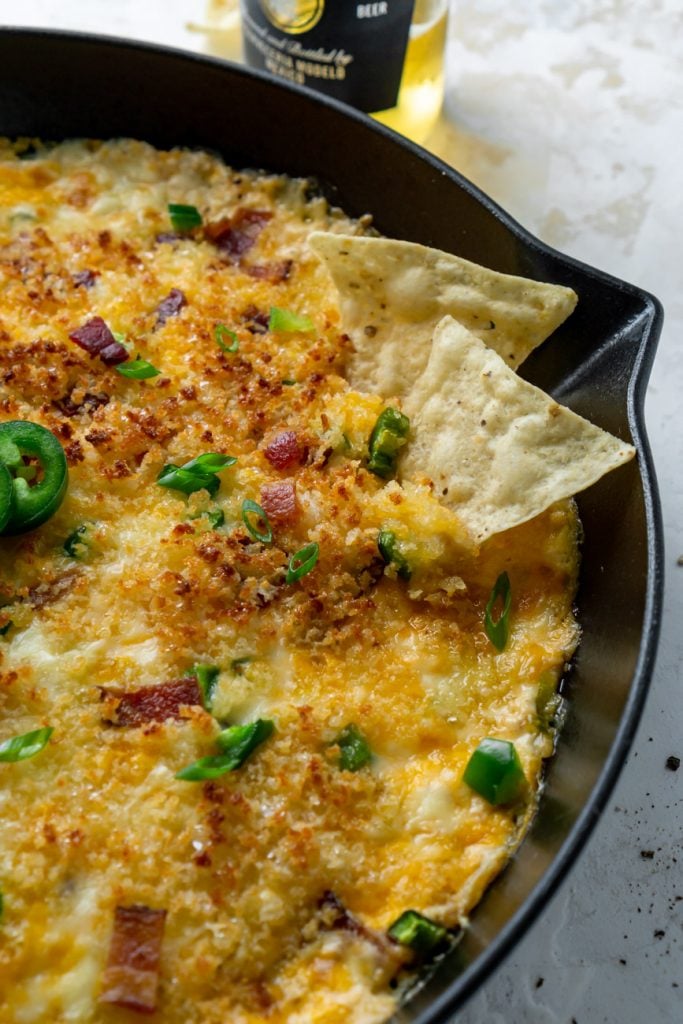 chips dipping into jalapeno popper dip