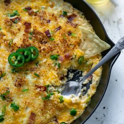 jalapeno popper dip in a skillet with a silver spoon