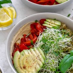 two pesto chicken power bowls with lemon wedges
