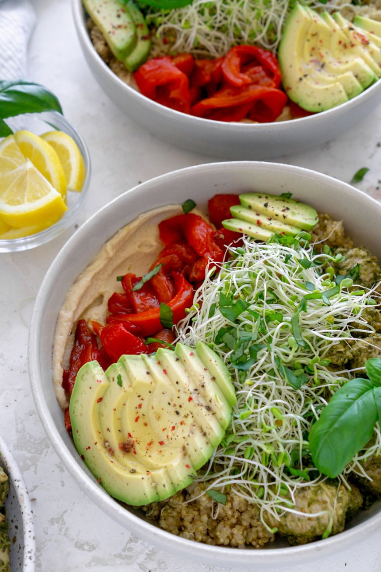 two pesto chicken power bowls with lemon wedges