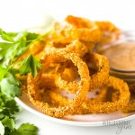 onion rings on a white plate with lettuce