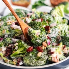 broccoli salad in a bowl with a wooden serving spoon