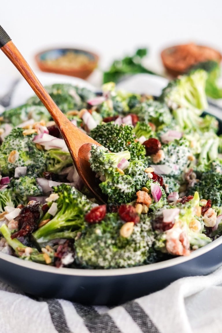 broccoli salad in a bowl with a wooden serving spoon