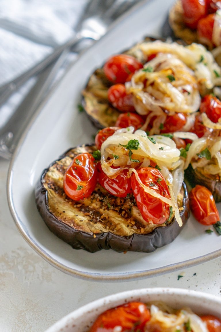 baked eggplant steaks on a plate with a fork