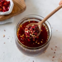 chili garlic sauce in a glass jar with a spoon