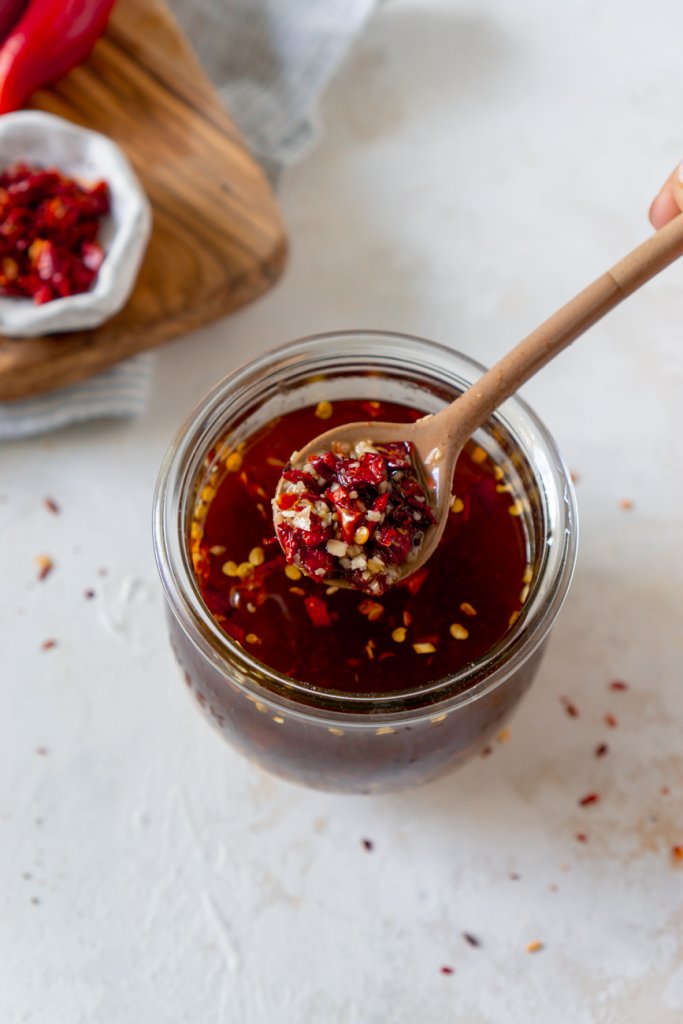 chili garlic sauce in a glass jar with a spoon