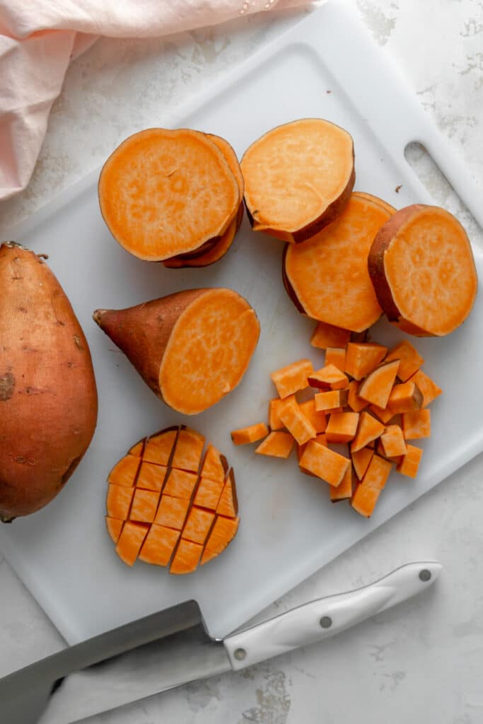 Sweet potato rounds and cubes on a cutting board.