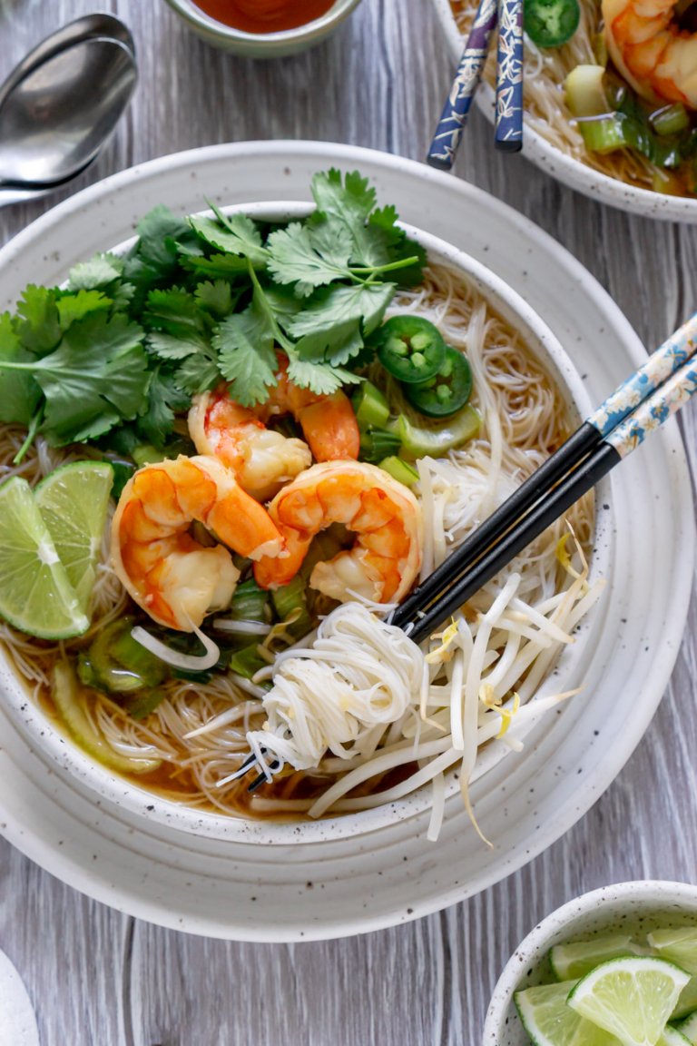 shrimp pho in a white bowl with chopsticks