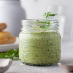 empanada sauce in a glass jar, flowers behind