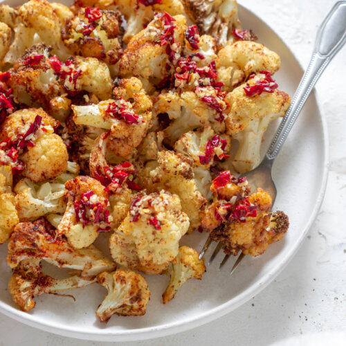 air fryer cauliflower on a white plate with a fork