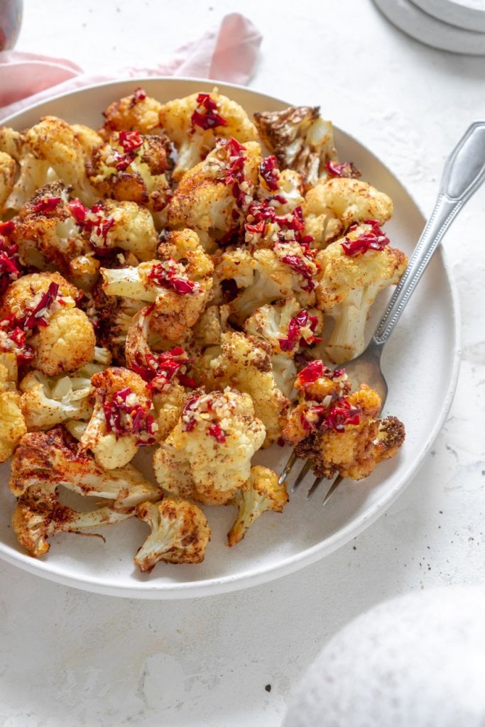 air fryer cauliflower on a white plate with a fork
