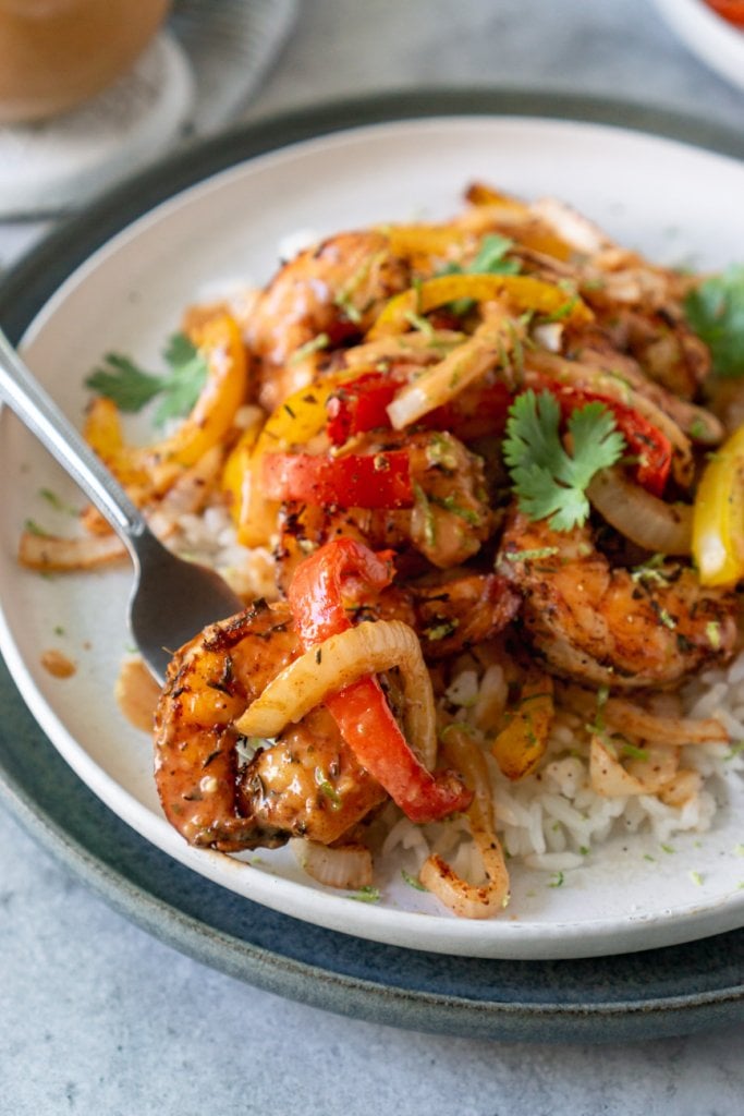 air fryer shrimp and peppers on a white plate with rice