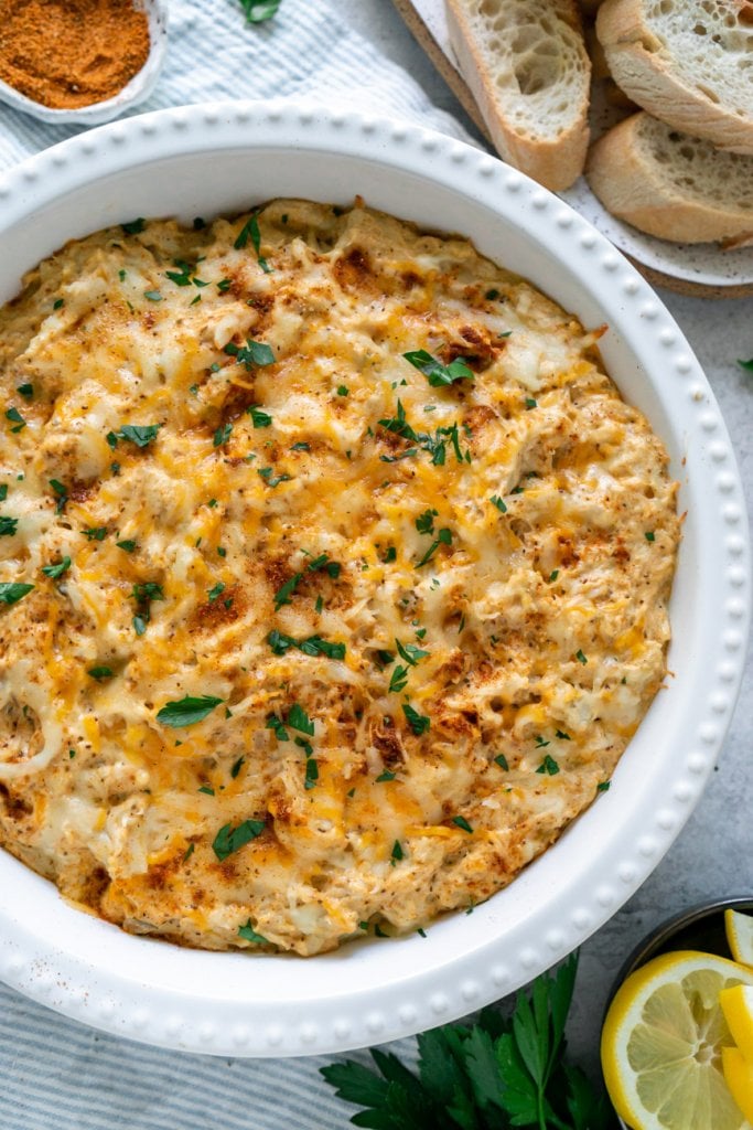 maryland crab dip in a white dish with sliced bread