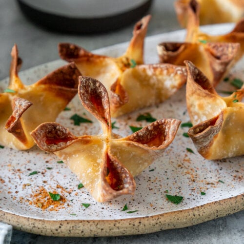 crab rangoons on an oval plate with lemon