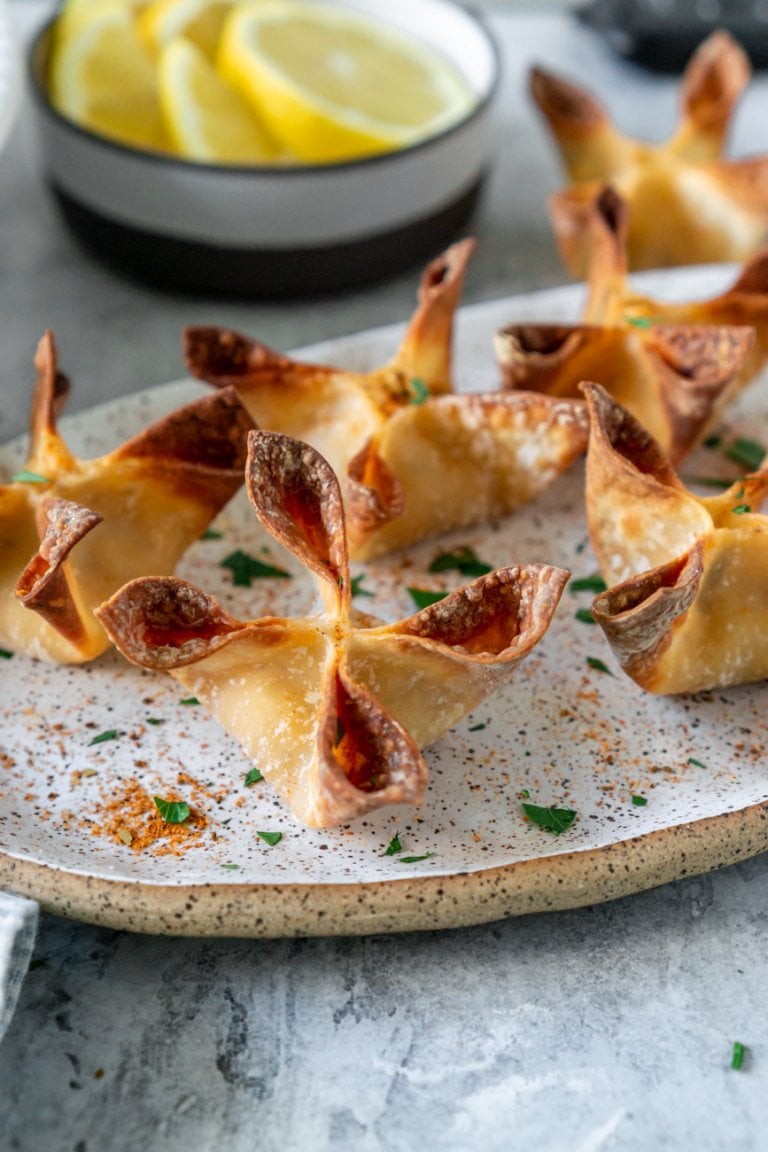 crab rangoons on an oval plate with lemon