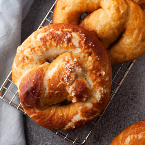 3 homemade soft pretzels on a cooling rack