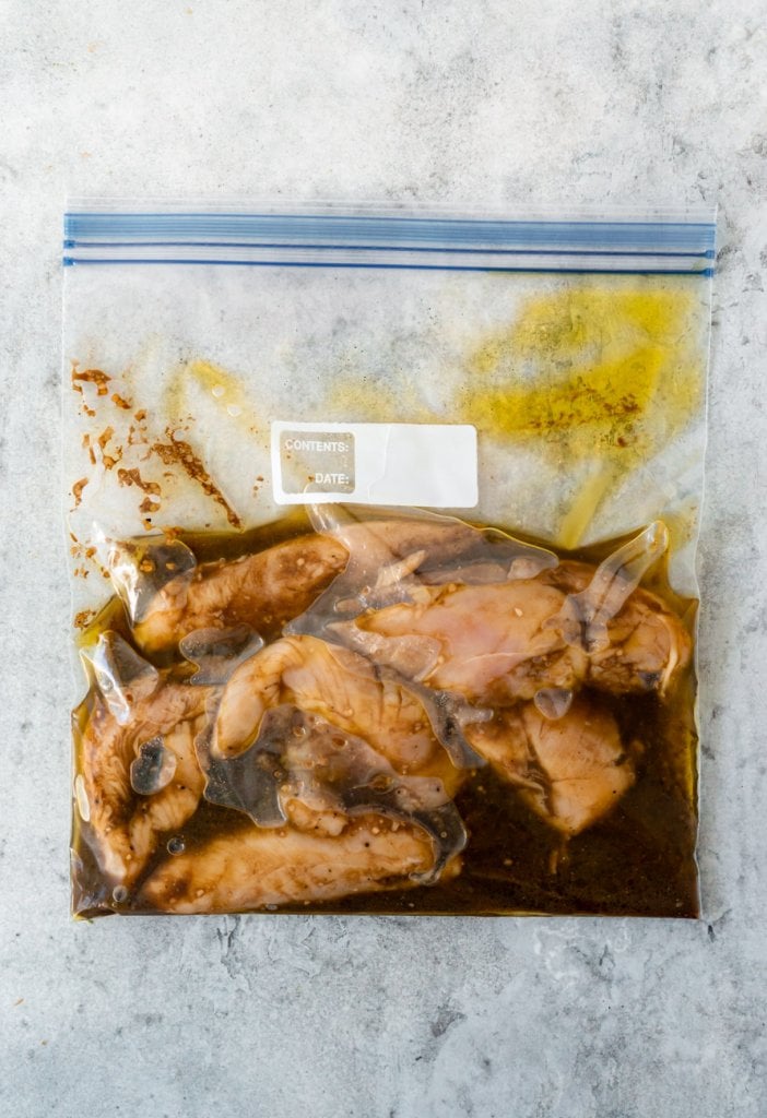 chicken marinating in a ziploc bag