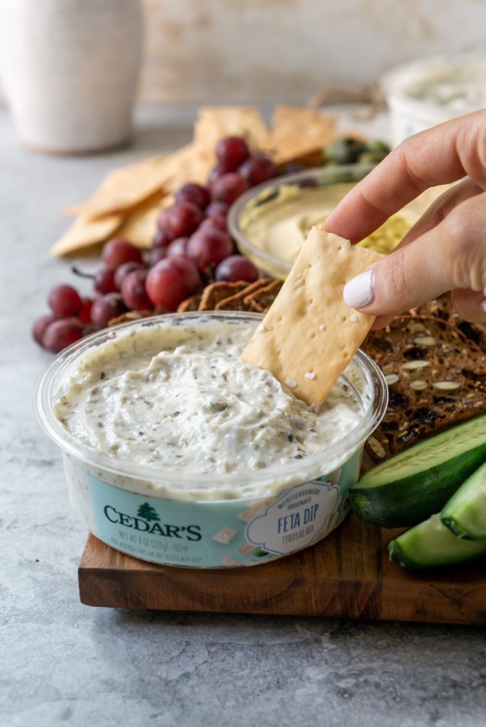 dipping a cracker in feta dip