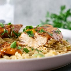 chicken sliced on a plate with orzo