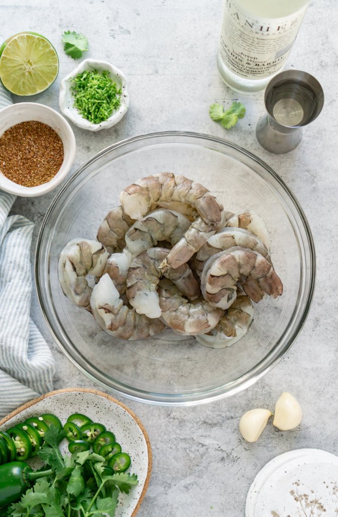 ingredients in bowls: shrimp, jalapeño, mezcal, lime, cilantro, garlic