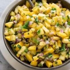 pineapple mango salsa in a brown bowl with a spoon