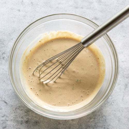 remoulade sauce in a glass mixing bowl with a whisk