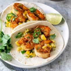 2 spicy shrimp tacos on a white plate