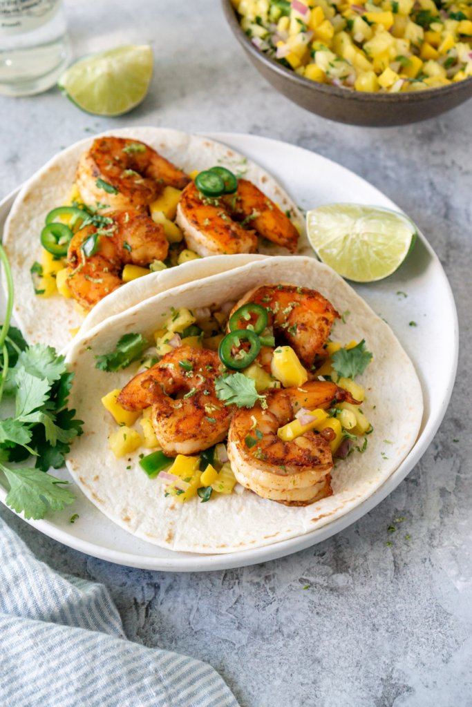 2 spicy shrimp tacos on a white plate