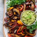 vegetarian fajitas on a platter with guacamole