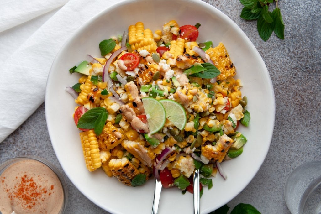 Avocado corn salad on a large white platter.