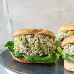 3 pineapple chicken salad croissant sandwiches on a grey plate