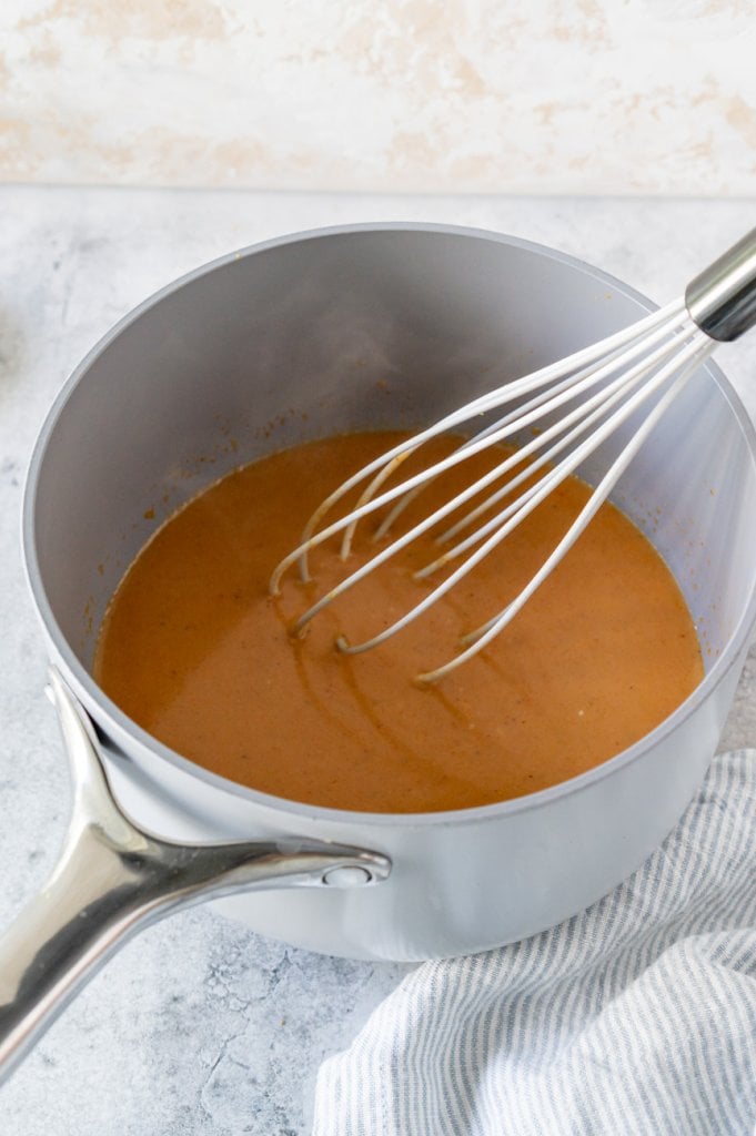 coconut curry sauce in a pot with a whisk