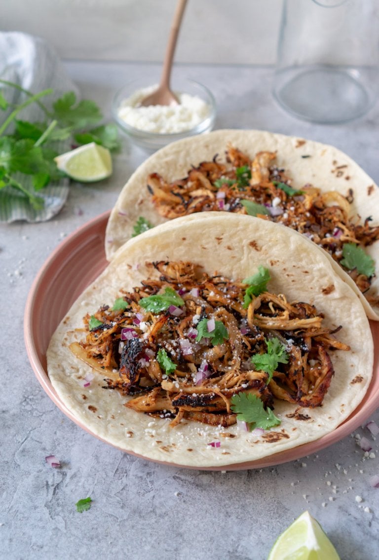 two turkey tacos on a pink plate