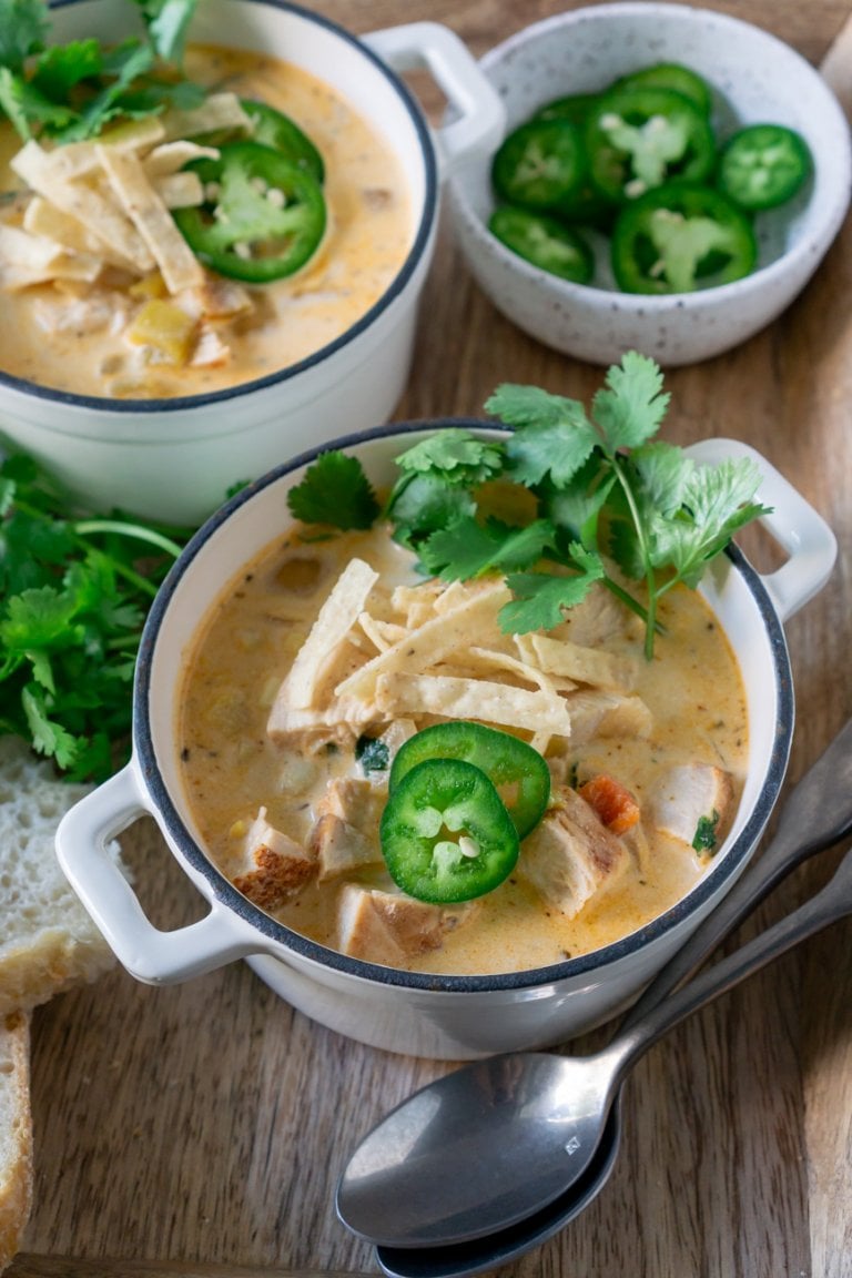 two bowls of leftover turkey white chili with two spoons on the side