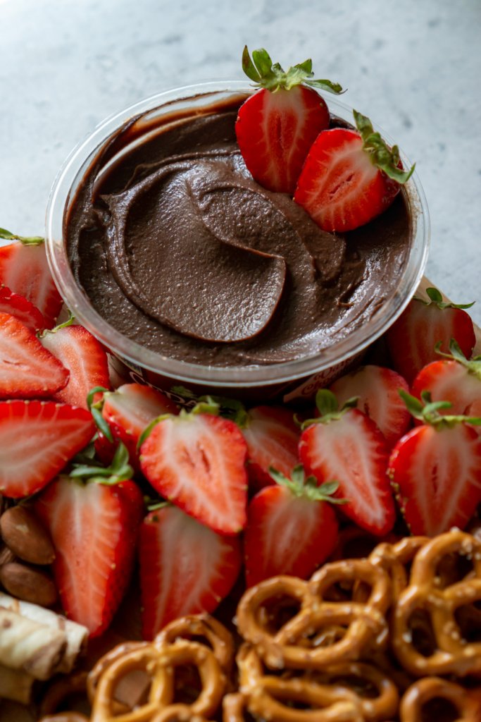 two strawberries in chocolate hummus