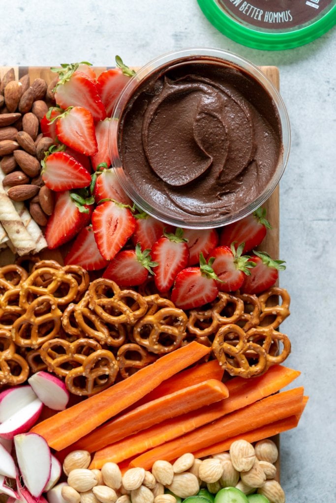 chocolate hummus with strawberries, pretzels, and carrots on a board