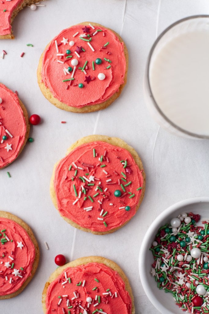 holiday sugar cookies with red frosting and sprinkles