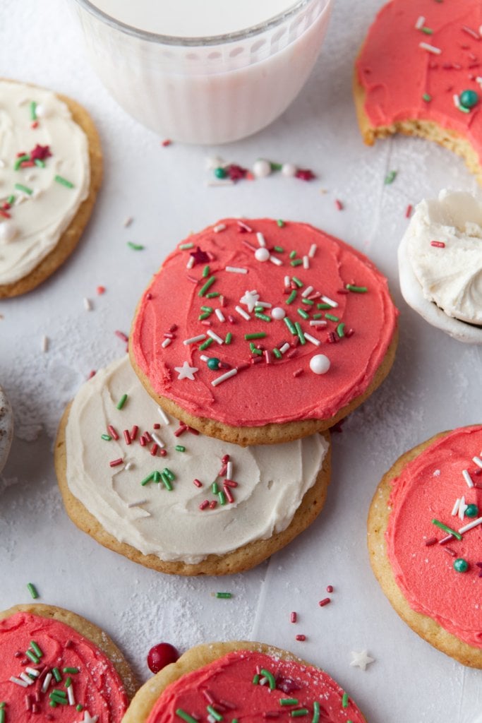 red and white holiday sugar cookies with a glass of milk