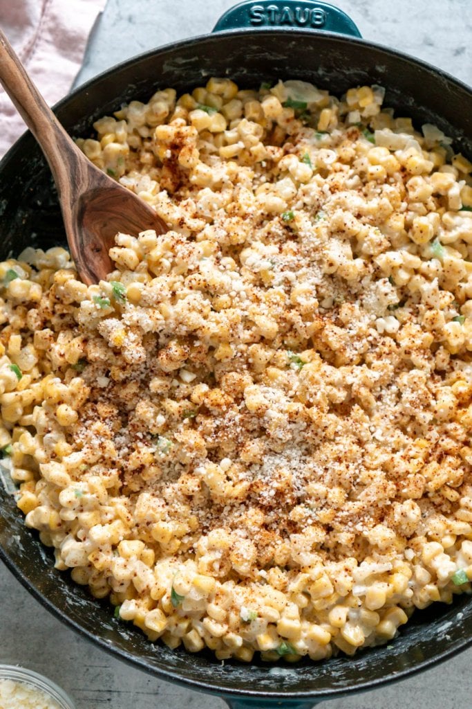 jalapeno creamed corn in a skillet with a wooden spoon