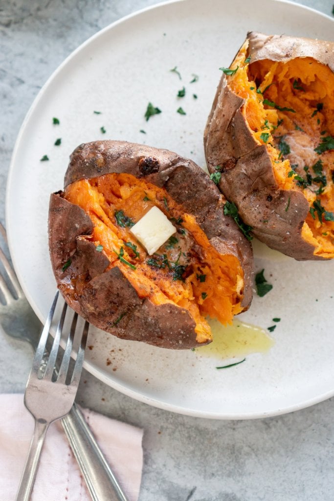 sweet potatoes on a white plate cut open with a silver fork