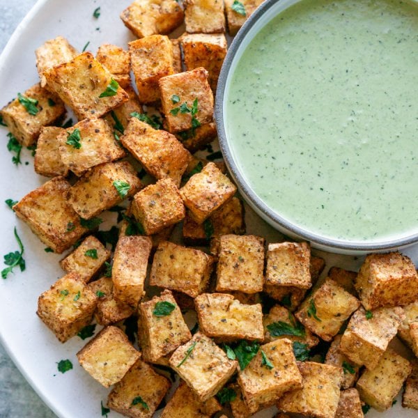air fryer tofu on a white plate with green goddess dipping sauce