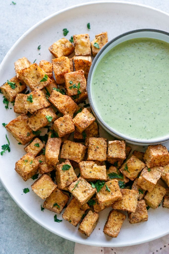 air fryer tofu on a white plate with green goddess dipping sauce