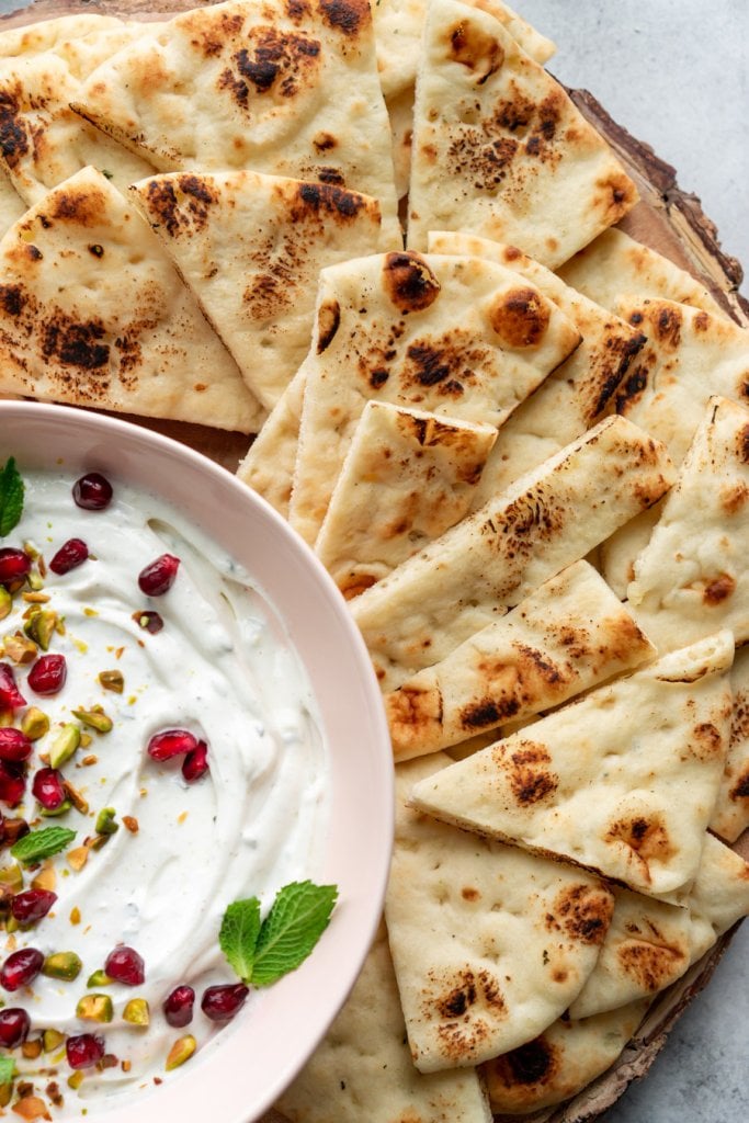 toasted naan on a serving tray with labneh dip