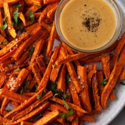 oven baked sweet potato fries on a white plate with dipping sauce