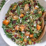 cranberry quinoa salad in a bowl with wooden spoons