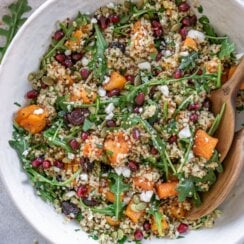 cranberry quinoa salad in a bowl with wooden spoons
