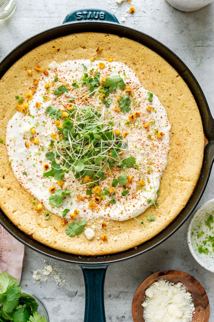 mexican cornbread in a cast iron skillet with cilantro on top